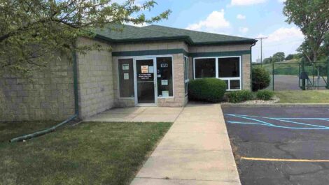 Outside view of a storage unit facility office with a walkway leading to the entrance.