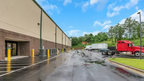 Self-storage building with a spacious parking lot, featuring well-marked spaces for easy access.