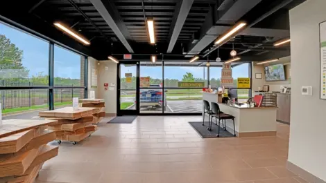 Spacious self-storage office featuring a counter, moving supplies, and a wide entrance with natural light.